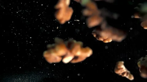 Slow Motion Capture of Fresh Walnuts Being Tossed in the Air Against Dark Stock Footage 272190168