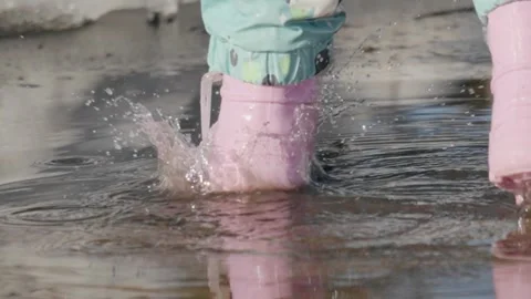 Slow motion capture of a pink shoe making a splash in water during a spring day Stock Footage 331740955