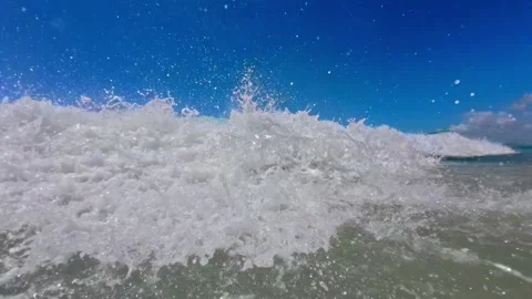 Slow motion captures an ocean wave crashing toward the camera with powerful Stock Footage 307520812