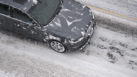 Slow motion of car driving on cold blizzard snow winter day Stock Footage 103980150