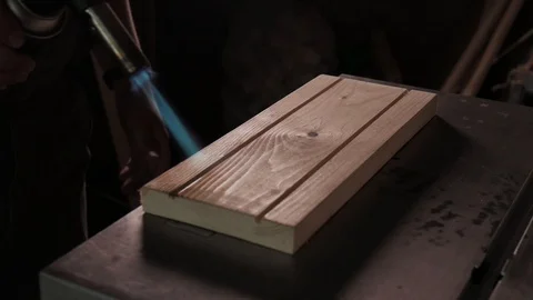 Slow motion. Carpenter burns boards with a gas burner for blackening Stock Footage 110685155