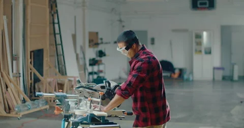 Slow motion of a carpenter working in the carpentry shop and cutting a wood Video stock 199616874