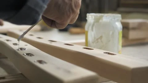Slow motion. A carpenter in the workshop lubricates furniture parts with glue in Stock Footage 201300321
