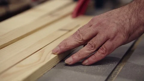 Slow motion carpenter wrinkled hands cutting wooden board on saw machine 스톡 동영상 121452244