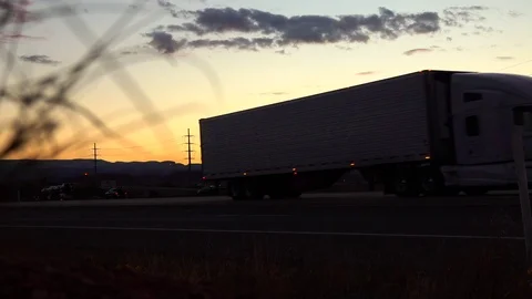 SLOW MOTION: Cars and semi-trailer trucks driving in Utah countryside at sunset Stock Footage