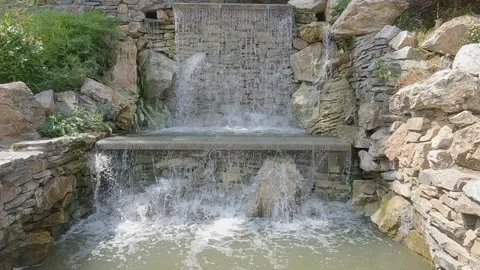 Slow motion of a cascading artificial waterfall made of stone Vídeo Stock 345303585