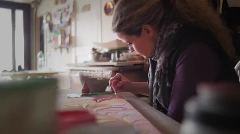 Slow motion of ceramic maker filling pencil strokes on terracotta with rubber Stock Footage 61952170
