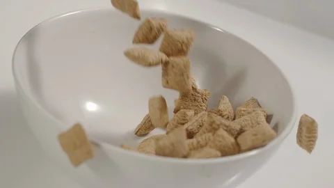 SLOW MOTION: Cereal bites pouring in a white dish Stock Footage 108959504