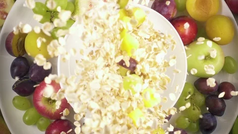 Slow motion cereal falling in a bowl against white background Stock Footage 92374752