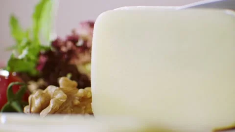 Slow motion cheddar cheese is cut with a knife. Stock Footage 132347936