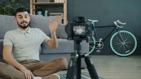 Slow motion of cheerful Arab man vlogger recording video with camera for vlog in Stock-Footage 132254292