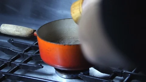 Slow motion - Chef adding pepper to pan of boiling soup water in kitchen Stock Footage 86536361