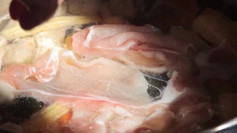 Slow motion of chef adding raw pork to Homemade Sukiyaki or Shabu Stock Footage 159004249