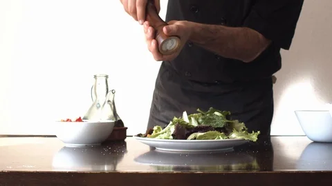 Slow motion of a Chef adding salt to a salad Video stock 128288611