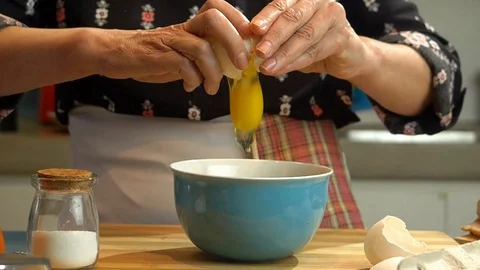 Slow Motion of a chef breaking an egg into a bowl Stock-Footage 128002598