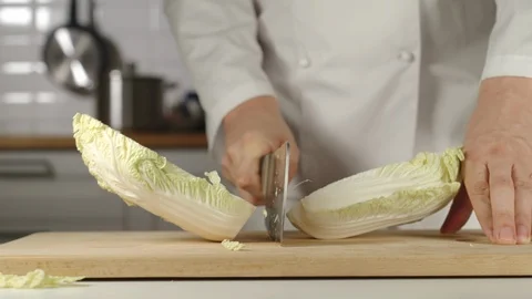 SLOW MOTION: Chef Chopping A Head Of White Chinese Cabbage On Wooden Board Видео 114797448