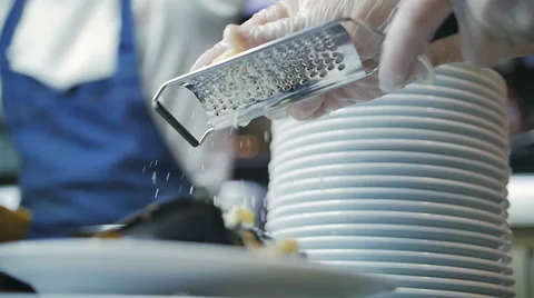 Slow motion of a chef grating parmigiano-reggiano cheese with steel grater on Stock Footage 69033403