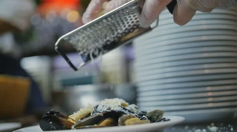 Slow motion of a chef grating parmigiano-reggiano cheese with steel grater on Video stock 69033493