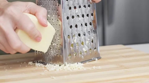 Slow motion of chef grating traditional parmesan cheese with steel grater on the Stock Footage 306812423