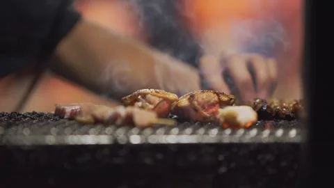 Slow motion of chef grilling seafood with torch flames at Japanese night yatai Stock Footage 321758674