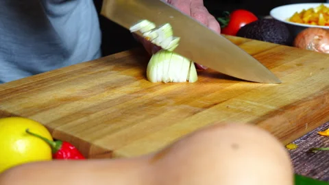Slow motion of chef hands in home kitchen cutting an onion Stock Footage 302301935