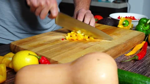 Slow motion of chef hands in home kitchen cutting an orange bell pepper on .. 库存影片 302302978