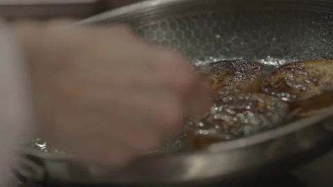 Slow motion chef pouring juice on meat cooking in pan Stock Footage 336366727