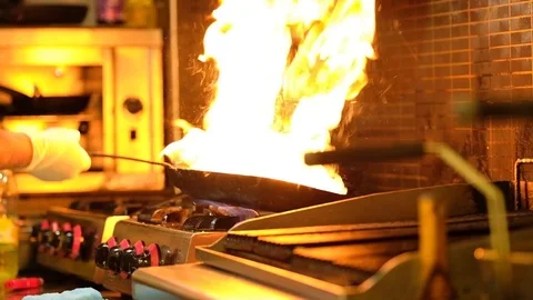 Slow Motion Chef in Restaurant Kitchen at Stove With High Burning Flames Stock Footage 105268481