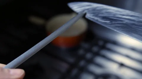 Slow motion Chef sharpening knife with steel sharpener, in commercial kitchen Stock Footage 86536902