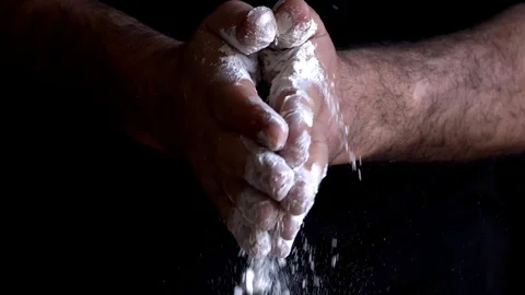 Slow motion of a Chef spreading flour on a black background Video stock 128504512