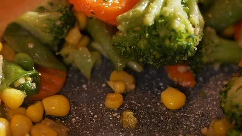 Slow-motion of chef stirring freshly-cooked vegetables on the frying pan. Stock Footage 107438166