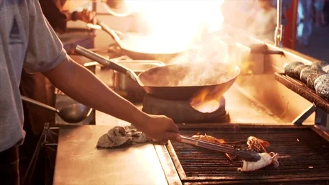 Slow motion of chefs cooking grilled vegetables and seafood on fire. Cambodia Stock Footage 106723631