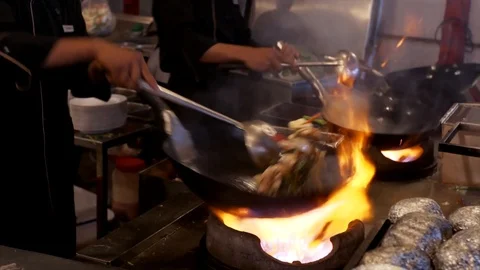 Slow motion: chefs prepare stirring wok with vegetables on frying pans. Cambodia Stock Footage 106723777