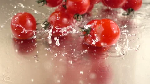 Slow motion cherry tomatoes and water splashes Stock Footage 68660526