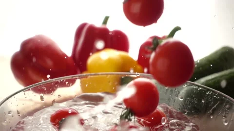 Slow motion Cherry tomatoes falling into the water Stock Footage 68660499