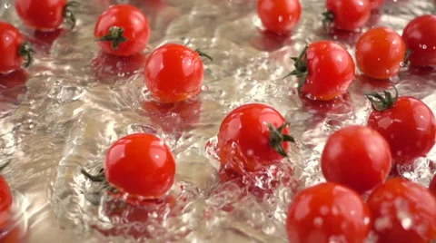 Slow motion Cherry tomatoes spilling into the water Stock Footage 68660553