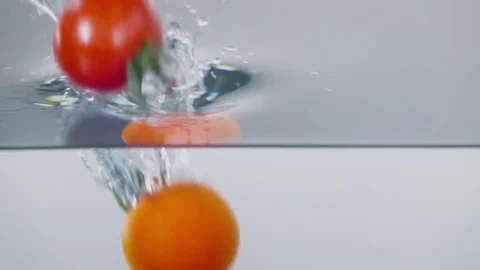 Slow-motion cherry tomatoes through water Stock Footage 79050839