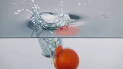 Slow-motion cherry tomatoes through water Stock Footage 79050879