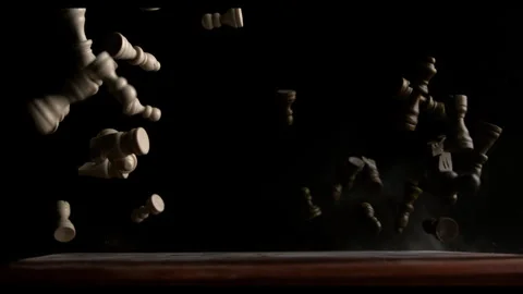 Slow Motion of a Chess Board on a Table with Pieces Scattering Against a Black Stock-Footage 270404230