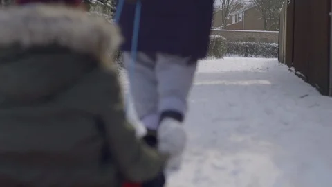 Slow motion child being pulled through the snow on a sled Stock Footage 86748130