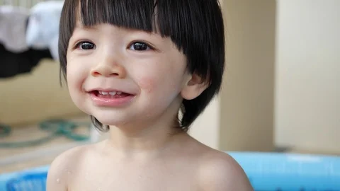 Slow motion child boy smiling freshness with playing water in small baby pool, h Stock Footage 89210283