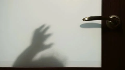 Slow motion. The child knocks on the door and pulls on the doorknob to open it Stock Footage 154874303