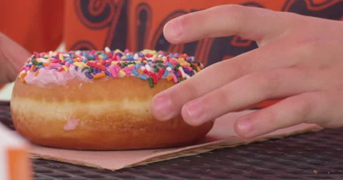 Slow Motion Child Picks Up a Donut with Sprinkles on It Stock Footage 61468015