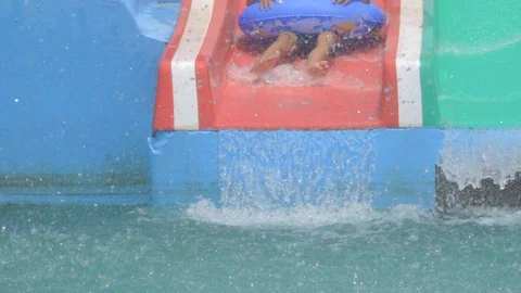 Slow motion child slide on slider in water park on summer holiday 库存影片 88189599
