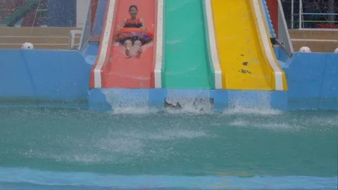 Slow motion child slide on slider in water park on summer holiday Видео 88190876