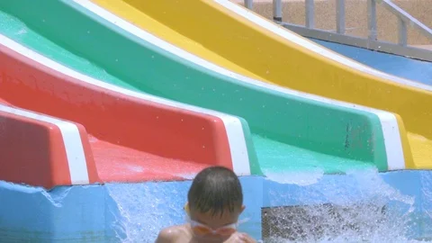 Slow motion child slide on slider in water park on summer holiday Stock Footage 88191004