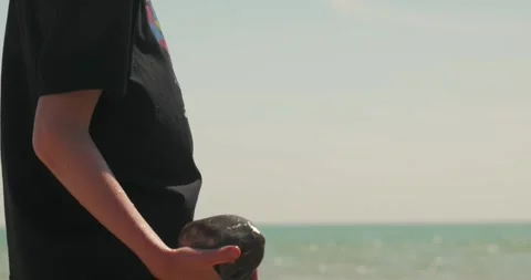 Slow motion child tossing a stone on Littlehampton beach Stock-Footage 335119237