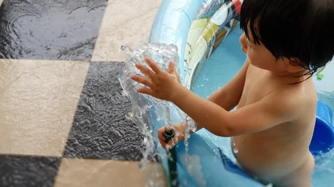 Slow motion, child using hand play water splashing in rubber hose have fun Stock Footage 89249814