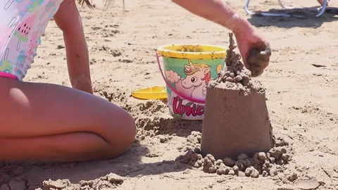 Slow motion children playing with sand on the beach building sand castle by Vídeos de archivo 270123655