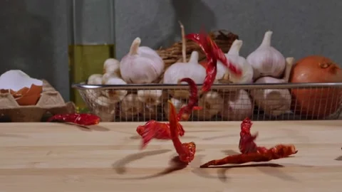 Slow motion chilli drop on wood cutting board. Food ingredients. Cooking concept Stockbeeldmateriaal 232966442